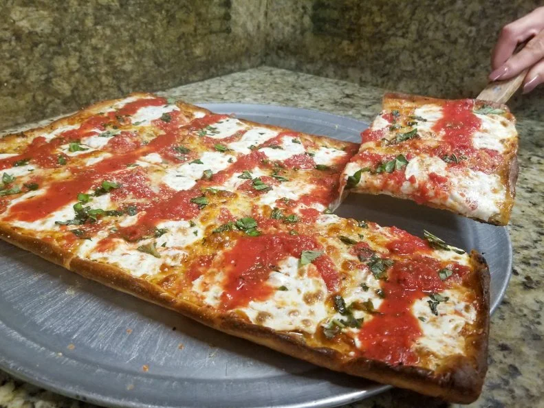 In the United States, most purveyors of pizza by the slice focus on New York City-style pies. Café SíTALY’s Alessandro Spenato does sell those foldable thin-crust slices, but his real infatuation is old-fashioned crispino. In Italy, home cooks who do not have access to a brick oven or pizza stone cook rectangular dough in a pan. In the Big Apple, that thin and crispy square, which looks kind of like Sicilian but without the thick bready base, is known as Grandma-style. “We may not be the only ones to make this unique style of pizza outside of a home kitchen or the streets of Brooklyn,” says Spennato. “I can assure you that ours is the best.” And yes, customers can sample a slice.