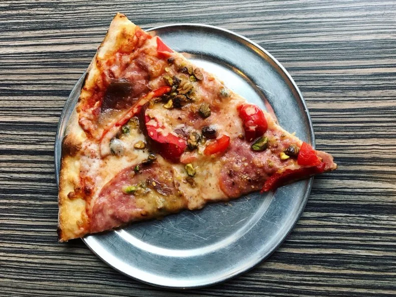 Pie Pushers has been pushing pies on Durham locals since 2011. Owners Becky and Mike Hacker combine their respective Midwestern and New England roots with a bit of regional flair. Their specialty pies, available by the slice, bring local produce and meats together with artisanal ingredients from across the country. For instance, their 1243 pie features a mix of salami with pistachios, bell peppers, caramelized red onions, smoked gouda and mozzarella with tomato sauce on a hand-tossed New England-style crust. A standout from the start, this pizza operation began as a food truck before branching into a brick-and-mortar restaurant, and later, a pizza concession stand in the Durham Bulls Athletic Park.