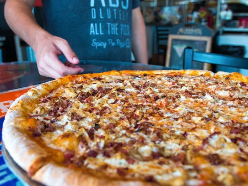 New York-style pies on the Midwest prairie is what you’ll find at this North Dakota fixture that’s a favorite of locals. When Spicy Pie’s first shop opened in Downtown Fargo in 2010, it filled the need for pizza by the slice in the steadily growing city. Today, the operation has six locations across the state. Unlike many pizzerias that only offer basic options by the slice (like simple cheese or pepperoni), this place features an extensive selection that can be customized with any toppings from the menu. All their specialty pies are also available by the slice, including the Margherita, The Carnivore and the Chicken Bacon Ranch. There’s more to the menu than just pizza, but the jumbo, foldable slices and 18-inch pies are definitely the all-stars. 