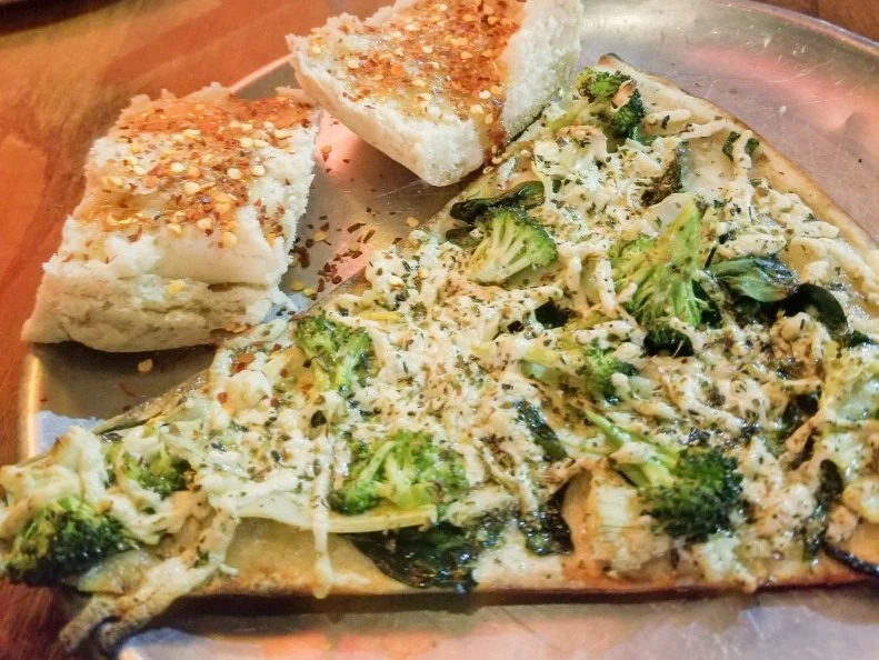 Talk about groundbreaking: When Yia Yia’s opened its doors in 1993, it was Lincoln’s first pizzeria to offer thin-crust by the slice. The place continues to draw the crowds with its customizable pies that can be tweaked with different toppings, cheeses and sauces to suit each customer’s preference. Pretty much every kind of pie on the menu is available by the slice, even the specialty pizzas like The Local. This popular pick comes loaded with a meat-lovers’ combo of bacon, hamburger, pepperoni and sausage, along with mushroom, bell pepper and onion, all piled atop a marinara and mozzarella base. Once you choose your slice, don’t sleep on the impeccable beer selection that favors craft brews. There are more than 350 bottled beer options available, along with an ever-changing array of drafts. 