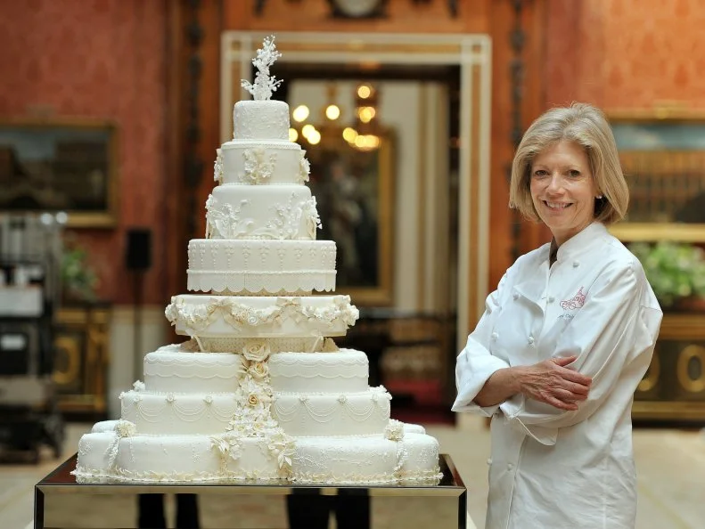 Fiona Cairns stands next to the Royal Wedding cake that she and her team made for Prince William and Kate Middleton, in the Picture Gallery of Buckingham Palace in London on April, 29, 2011.  AFP PHOTO / WPA POOL / JOHN STILLWELL (Photo credit should read JOHN STILLWELL/AFP/Getty Images)