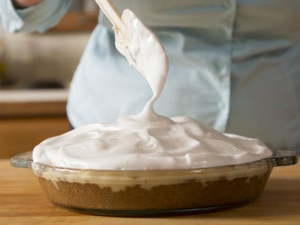 Baker spreading meringue on top of flapper pie.