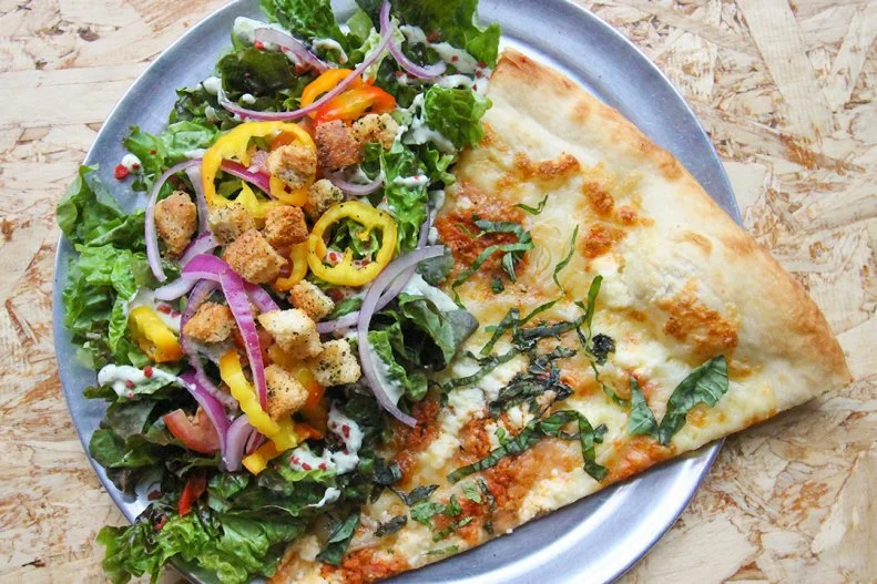 A slice does not always a meal make. But an oversized slice served alongside a heap of salad will give you enough energy to make it through a punk rock show, which half the employees behind the counter of this late-night pizza place seem to be either coming from or headed to. For $8, you can choose from nine kinds of pies and tack on either the Rabbits salad, made with faux-bacon bits, sliced hot peppers, tomatoes, housemade croutons and vegan ranch dressing, or the Caligula, a vegan Caesar. Sizzle Pie also sells merch, including the “Death to False Pizza” bumper stickers you’ll see all around Portland.