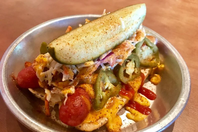 Killer brews and killer dogs make up most of the menu at this Pacific Northwest spot. You can get your pick of the classics or the creative — or the Tideflats, which pretty much is a monstrosity of it all. Two all-beef hot dogs are served open-faced on a steamed poppy seed bun with classic toppings like mustard, ketchup, onions and sweet relish. Sport peppers, pickled jalapenos and sauerkraut are added before housemade chili, nacho cheese sauce and housemade Southern slaw are piled on and it’s all finished off with a pickle spear and a dash of the house seasoning. 