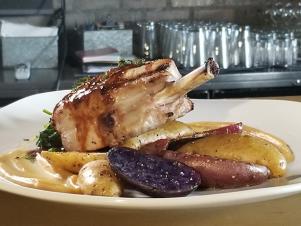 Pork Chop on plate on table at Turnhouse Grill, as seen on Comfort Food Tour, Season 2.
