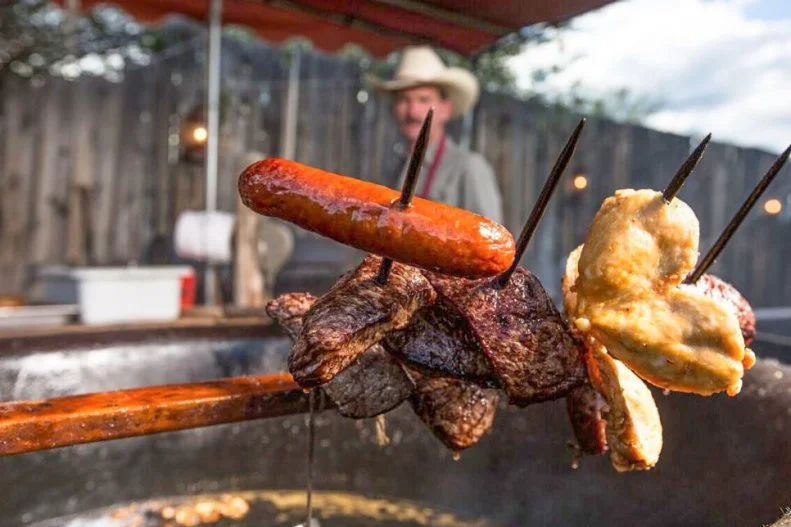 Ever wonder how cowboys ate their hot dogs? Straight off the tines of a pitchfork, sizzling hot from bubbling cauldrons of oil heated by wood fire, if you ask the folks at Pitchfork Fondue. Offering prime views of the Wind River Mountains, this Pinedale spot is one of the most popular places to experience a western cookout in the Cowboy State. While most places grill their meats over an open flame, these guys prefer to deep fry their steak, chicken, potato chips and onion rings. And each all-inclusive meal begins with buffalo brats cooked the same way as well as regular old deep fried hot dogs for kids â   in actual age or mental maturity â   upon request.