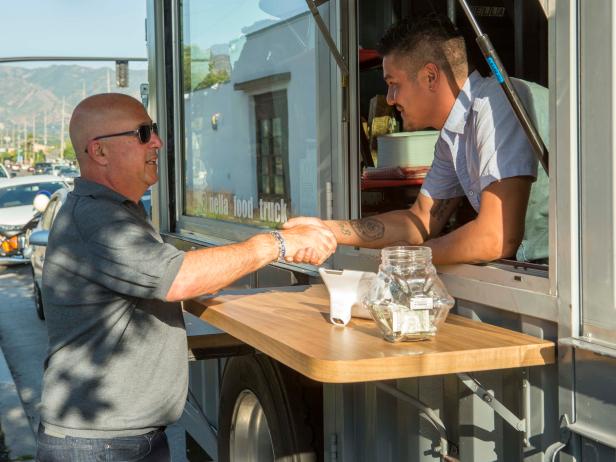 Host Andrew Zimmern chats with owner Juan Pablo Watcherdorff, 32, after sampling a prosciutto and a margherita pizza from the Nella food truck, a $200k wood-fired pizza truck custom built in a shipping container mounted on a truck bed, as seen on Big Food Truck Tip, Season 1.