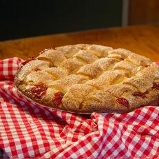 Large Strawberry Rhubarb Pie (strawberries, tangy rhubarb, buttery lattice crust) on table at Betty's Pie Whole, as seen on Comfort Food Tour, Season 2.