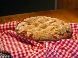 Large Strawberry Rhubarb Pie (strawberries, tangy rhubarb, buttery lattice crust) on table at Betty's Pie Whole, as seen on Comfort Food Tour, Season 2.