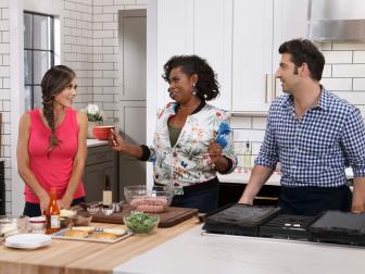 Host Jamika Pessoa demonstrates her Grilled Turkey Burger Stuffed with Pepper Jack Cheese and Topped with Grilled Peaches for fellow hosts Stuart O'Keeffe and Brandi Milloy, as seen on Let's Eat, Season 1.