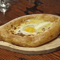 The khatchapuri at Oda House in New York's East village is a traditional Georgian bread loaded with feta and mozzarella cheese, and topped with an egg and tons of butter, as seen on Food Network's Baked, Season 1.