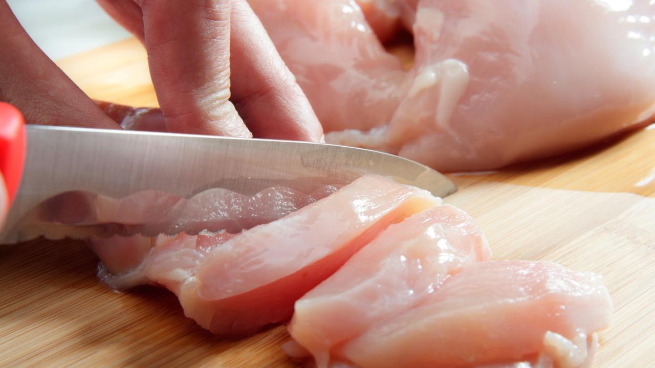 Raw Chicken Cutlets on a Cutting Board: Cutting chicken breasts