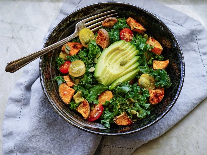 Kale, roasted yams and avocado salad on stone background/ vegan salad/ healthy/ paleo diet