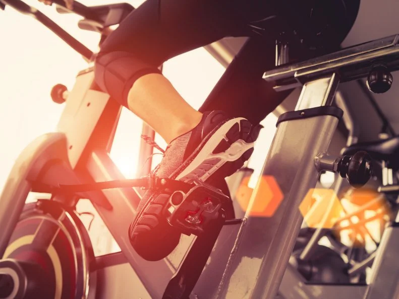 Exercise bike cardio workout at fitness gym of woman taking weight loss with machine aerobic for slim and firm healthy in the morning.