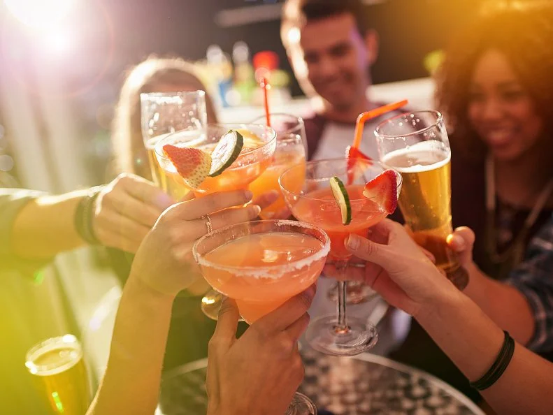 Shot of a group of people toasting with their drinks at a nightclub