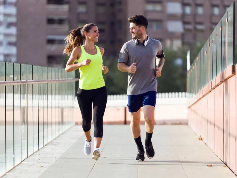 Portrait of beautiful couple running in the street.
