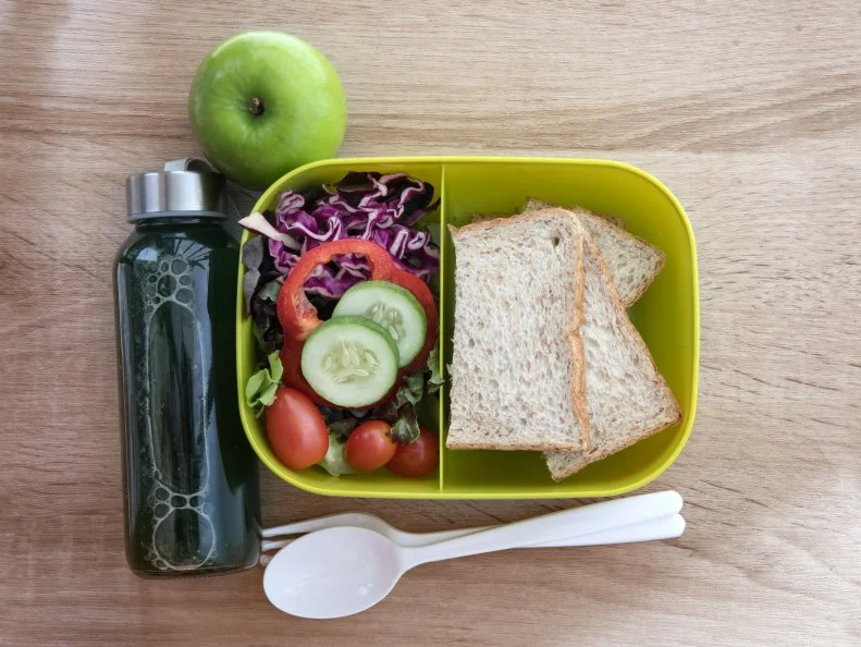 Healthy Lunch box with grain bread and green vegetable and fruit juice bottle on wooden background  ,Healthy eating clean food habits for diet concept , top view and overhead shot