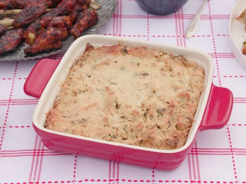 This cheesy Collard Green and Artichole dip is served with toasted garlic bread slices as seen on Cajun Aces