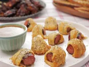 these wrapped smoked pork saugage bites are called Kajun Kolaches and is served wih Creole Honey Mustard. The sausage is made at one of Sam & Cody's restaurants as seen on Cajun Aces