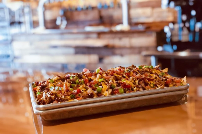 Beer and food go hand in hand at Ascension Brewing Co. in Novi. The animated taproom of this microbrewery is filled with diners knocking back Binaural Beats sour IPAs alongside Mr. Piggins Brewery Nachos made from scratch with 12-hour-cooked pulled pork, red onion, green onion and pico de gallo. Cheddar-ale sauce tinged with the breweryâ  s own beer and a Sriracha-bourbon BBQ sauce boldly elevate the dish.