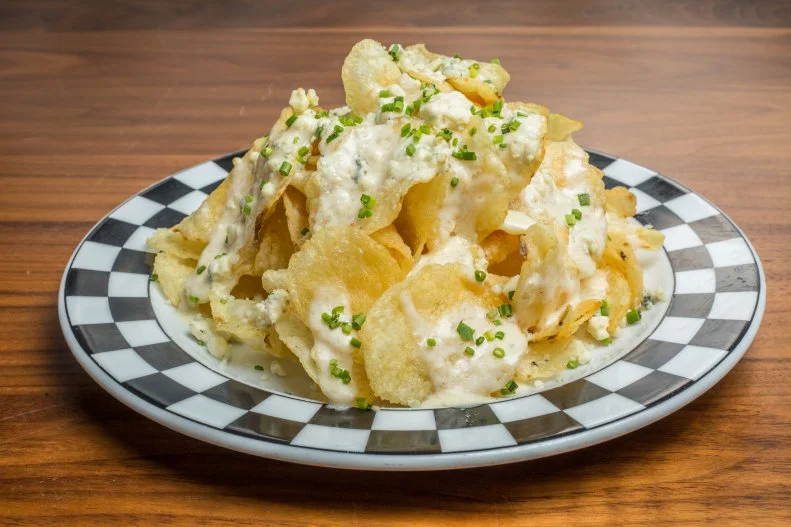 Leaving Cap City Fine Diner and Bar — part of the Cameron Mitchell Restaurants empire in Columbus, Dublin and Gahanna — without springing for a slice of its three-layer chocolate cake would be disappointing. So would not partaking in the restaurant’s uniquely Buckeye State version of nachos: a mound of potato chips smothered in blue cheese, chives and Alfredo sauce.