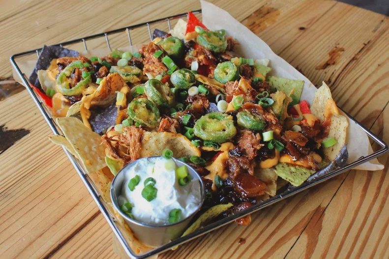 In a historic Waynesboro building that once produced iron stoves and brass candlesticks, the globally influenced Hops Kitchen and Basic City Beer Co. now churn out pub food and craft beer. The kitchen turns to the taproom to amp up its recipes, and the smoked pork nachos are a genius example of this culinary collaboration. They embrace a trio of different brews: The 6th Lord IPA for the beer cheese, Oopsproch lager for the bacon jam, and Bask DIPA for the beer-battered crispy jalapeno peppers.