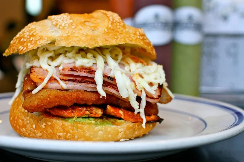 Created in Oaxaca and adopted by Chicagoans, the cemita is a Mexican sandwich that has become a principal dish in a city that is known for its love of meat-stuffed carbs. Similar to a torta but with its own sesame seed-studded bun, cemitas are filled with papalo (a spicy-citrusy Mexican herb), avocado, shredded Oaxaca cheese and, generally, plenty of meat. At Cemitas Puebla, owner Tony Anteliz bakes his own crusty buns in-house for his acclaimed sandwiches. The most popular pick, the Cemita Atomica, comes piled high with guajillo-chile-slathered roast pork, a slice of ham, traditional breaded pork Milanese, chipotle-pineapple sauce and all the customary accoutrements.