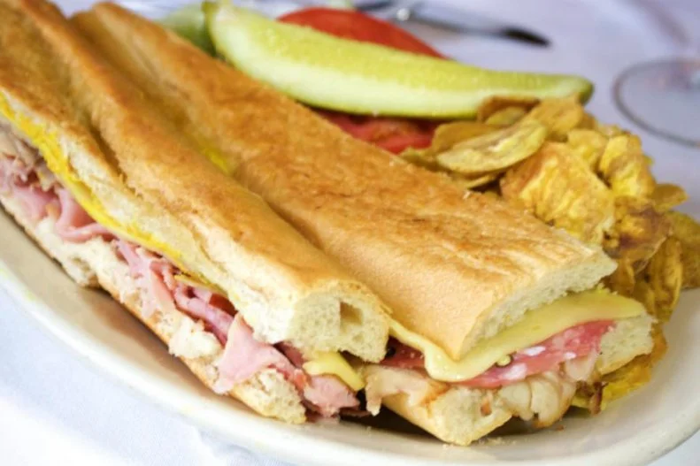 The Cuban sandwich is a misnomer on many levels â   neither the sandwich itself nor its culturally diverse fillings originated in Cuba. Itâ  s like an ode to the cultural fabric that made up its home city when it was created in 1915. Invented at Tampaâ  s Columbia Restaurant, the oldest dining establishment in the state, the iconic sandwich was actually called a mixto when it was first created. It combines Genoa salami from Italy, Spanish ham, Cuban-style mojo-marinated pork, Swiss cheese, German pickles and mustard, nestled in fluffy Cuban bread. The bread still comes from century-old La Segunda Central Bakery, which has been the supplier since shortly after the sandwich was invented.