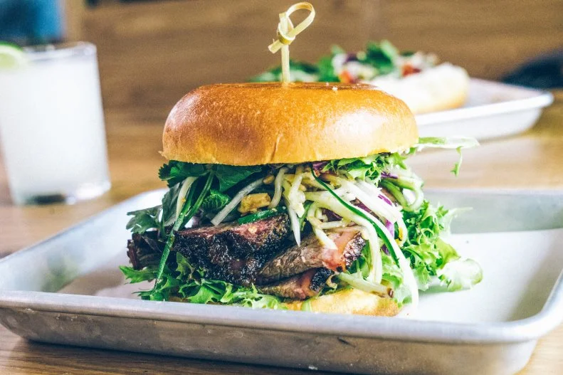 While the word barbecue means pork in the Carolinas, in Texas’ Hill Country, the term is synonymous with beef brisket. Aaron Franklin of Franklin Barbecue is consistently hailed as the leader of the pack. The no-reservations, counter-order barbecue joint has notoriously long lines — President Obama was the only person ever offered a reprieve — but the James Beard Award winner’s brisket can also be found at his new Asian-inspired smokehouse, Loro. Co-owned with Chef Tyson Cole of Uchi and Uchiko fame, Loro offers guests a chance to sink their teeth into Franklin’s smoked and grilled brisket sandwich, marinated in nuoc mam and finished with herbs and chile oil, sandwiches with zesty papaya salad, peanuts, chile aioli and thai herbs — hopefully with a slightly less onerous wait time.