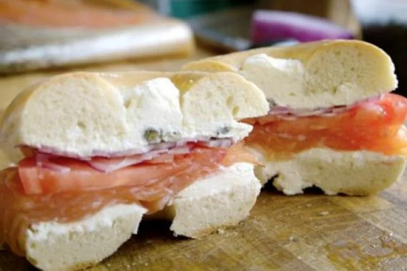 Bagels and lox are as representative of New Yorkâ  s melting pot as any dish. Eastern European Jewish bagels serve as the base for American cream cheese and cured salmon. The latter combines Scandinavian salmon and Native American smoking and drying techniques. That trifecta of ingredients creates the foundation for the iconic sandwich, along with onions, capers and tomatoes at bagel shops around the country. But the place to get it is Russ & Daughters on New Yorkâ  s Lower East Side. The historic â  appetizing storeâ   has been slicing foods that pair with bagels (like cream cheese and cured fish) in the classic Jewish tradition since 1914.