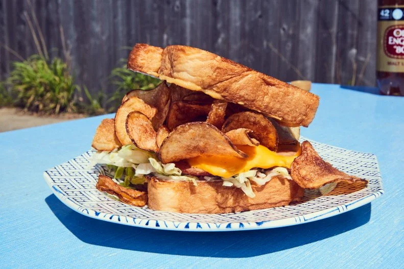 Kids all across America grow up eating bologna sandwiches. Young Southerners, however, up the ante with fried bologna. From the Great Smoky Mountains to the Mississippi Delta, rounds of cured pork (derived from Bolognese mortadella) are fried to a crisp, sandwiched between slices of white bread and flavored with various condiments, including near-mandatory mayo. At New Orleans’ Turkey and the Wolf, Mason Hereford griddle-fries three slices of locally made bologna, coats it with American cheese and accents it with house-made hot mustard, Duke’s mayo and shredded lettuce. That would be great on its own, but what really sets this monster of a sandwich apart is the crown of vinegar-brined potato chips sandwiched between butter-slathered thick-cut slices of Pullman bread.