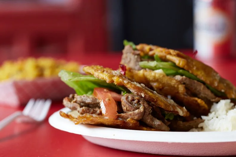 The jibarito — a sandwich of meat, lettuce, tomato, onion and cheese, cradled between two slices of fried, salted green plantains — has engendered some serious controversy. One side claims it was invented by Chicago restaurateur Juan Figueroa at now-closed Borinquen. Others say it was created in rural Puerto Rico. Wherever its inception, one thing is certain: The sandwich has become a Windy City obsession. Nearly every Puerto Rican joint in the city serves a rendition. The popular sandwiches are the name of the game at The Jibarito Stop in Pilsen, where you’ll find a banner version with cheese, meat, lettuce, tomato and onion between salted green fried plantains.