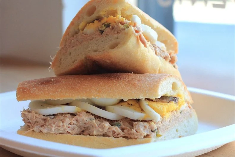 For the past 50 years, cans of tuna have graced nearly every pantry in the United States. Because of that, a lot of Americans turn to the tuna salad sandwich when the fridge runs down to its bare bone essentials. At BKLYN Larder, however, the tuna, egg and anchovy sandwich is a dish worth celebrating. It starts with a Grandaisy Bakery flauta baguette thatâ  s sliced down the middle and smeared with mayonnaise on one side, drizzled with olive oil on the other. Brooklynâ  s best tuna salad is then topped with briny bursts of capers, a sliced, hard-boiled egg and two whole Agostino Recca anchovies laid across the whole thing with a quick squeeze of lemon for an innovative carb-loaded riff on a Nicoise salad.