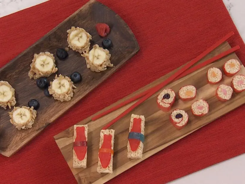 Fruit Sushi prepared by food and lifestyle expert Bandi Milloy quick and easy, made with one bannana covered with peanut butter, rolled in crispy rice cereal until completely covered, sliced into pieces, garnished with blueberries and rasperries, quick and easy ready to serve,  as seen on Food Network Lets Eat Ep 108.