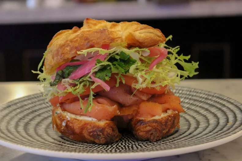 This artsy, Old World cafe offers the perfect respite from the bustling Loop during the week. Grab a seat and channel Paris while biting into the smoked salmon croissant, thin slices of smoked salmon sitting atop a mound of scallion cream cheese and crowned with a light lemon-and-dill herb salad with pickled red onions. The croissants â   from New York's Lecoq Cuisine â   are baked fresh daily.