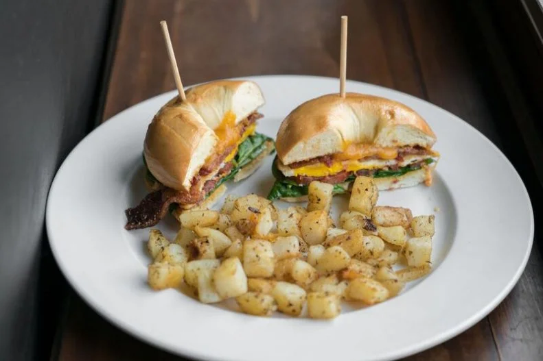 This Greek-inspired breakfast, brunch and lunch spot turns up the heat on its morning sandwich with the addition of chile aioli. The sandwich is made by topping a NYC Bagel Deli bagel with a fried egg, cheddar, spinach and tomato, your choice of peppered or veggie bacon and a spread of that fiery aioli.