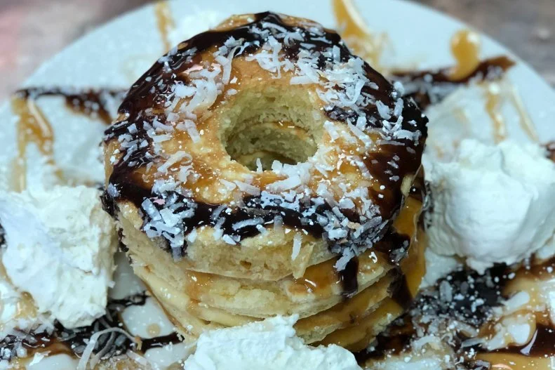 Luring in locals with pure comfort food is the mission at Magee's Curbside. In the afternoons that translates to bourbon caramelized onion burgers and short rib burritos, and in the mornings to bacon-egg-and-cheese empanadas and granola-crusted French toast. The ring-shaped house pancakes are especially clever. Marrying caramel, chocolate and toasted coconut, they are a spot-on ode to Samoas, the addictive Girl Scout cookies.