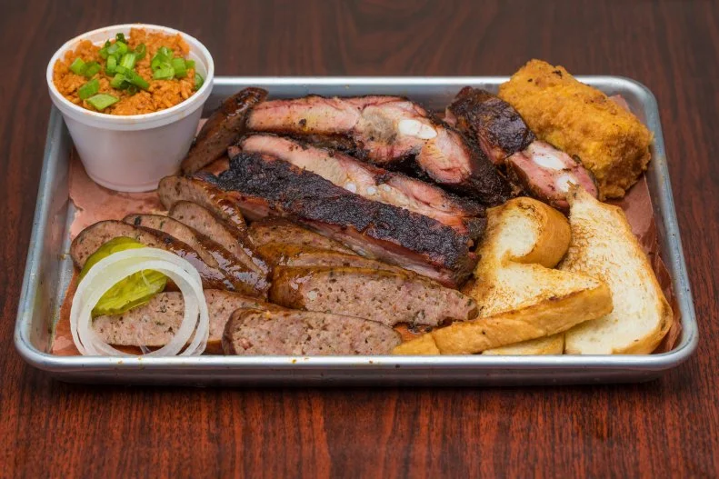 It's a family affair at this Houston staple in the Third Ward where co-founder Ray Busch still reigns as pitmaster, delivering hickory smoked meats and spicy smoked boudin in paper-lined baskets. Raw onions and tart pickles provide a crunch between bites of fatty beef rib, but the crunch you'll get from the famed gilded deep-fried corn on the cob is unparalleled.