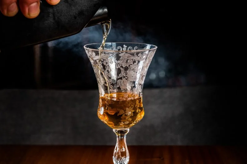 This option on Bresca’s drink menu inspired by Aurora Borealis is an homage to an ill-fated expedition to find the Northern Passage that left ships frozen in Canadian waters under the Northern Lights. It combines rye, Lucano Amaro, De Muller Aureo and Clement VSOP Rum, which is smoked at the table with cherry wood and served in a Nick & Nora glass.