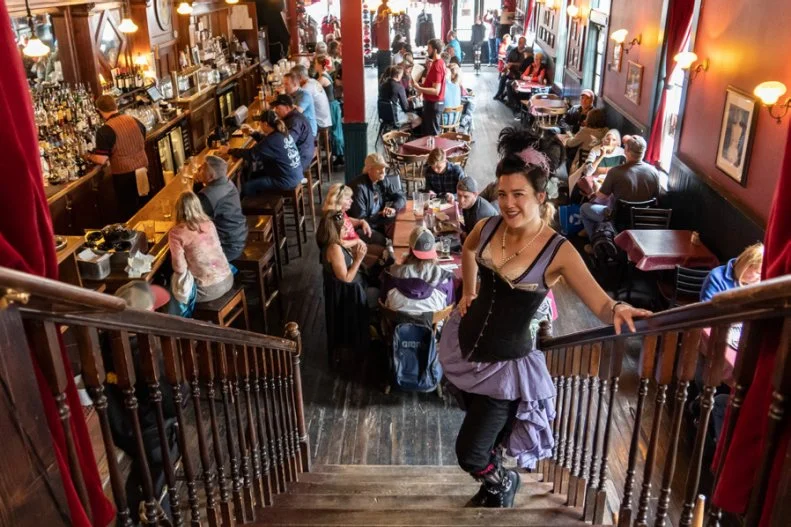 Back in the 1800s, Skagway was known as a goldrush town, with stores, lodging and saloons everywhere to keep up with the boom of new aspiring miners. The Red Onion Saloon was founded in 1898 and quickly earned a reputation as the finest saloon and dance hall in Skagway. The classic saloon vibes remain, with soaring ceilings, pendant lighting and plenty of wooden accents, and waitresses even wear corsets or period costumes. On the restaurant’s second floor is a museum dedicated to the saloon’s history as a brothel. With such a sordid history, it’s no wonder there have been unusual happenings. Bar goers have witnessed items flying off counters at random, seen a woman hanging above the dress case and heard disembodied voices. Some male employees have felt a shove on the stairs. Besides the spirited company, The Red Onion Saloon has earned its status as a favorite local bar for its equally spirited drinks and comfort-bar-food menu, including fan-favorites like nachos and chili.