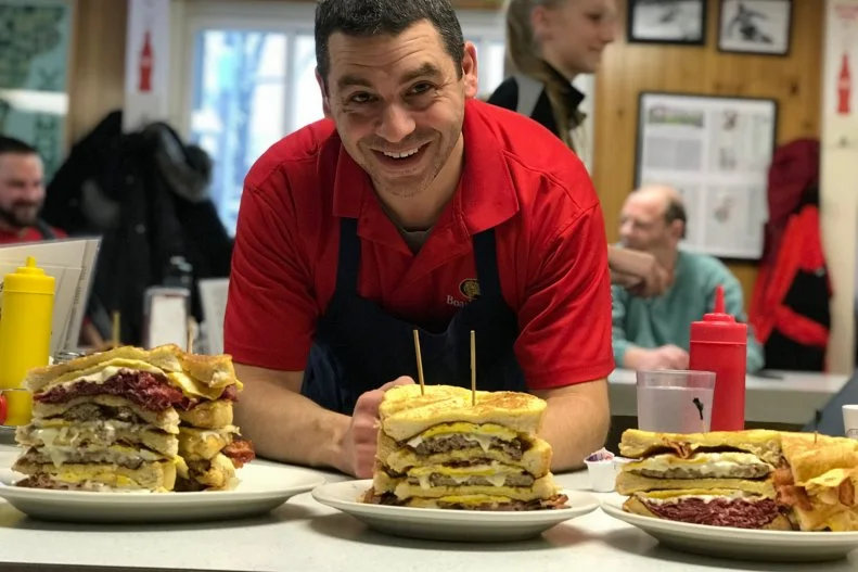 Even if you're dining solo, Handy's Lunch is the kind of place where you're bound to end up striking up a conversation with someone at the horseshoe counter. In fact, there are regulars who vie for the seat at the end of the counter so that they can chat with Janet Handy, owner Earl Handy's mother, who still comes in to make burgers and shoot the breeze. Earl is the third-generation owner of the venerated Burlington diner, which was founded by his grandparents as a mom-and-pop grocery store in 1945. The food menu began modestly with coffee, doughnuts and eggs, and expanded over the years to include breakfast and lunch. The signature specials have evolved over time too: When Earl was growing up, Handy's was known for specials like meatloaf Mondays and goulash Tuesdays, but he has put his stamp on the menu with a lineup of oversize breakfast sandwiches. Go big or go home with the Chuck Norris, a five-layer behemoth that weighs three-and-a-half pounds and features five pieces of French toast, four eggs, cheese, ham, bacon, sausage, a hamburger patty and corned beef — all held together by a 10-inch skewer (lest it topple over) and accompanied by a side of Vermont maple syrup. It begs to be savored, but there's a friendly competition among local high schoolers to see who can eat one the fastest.