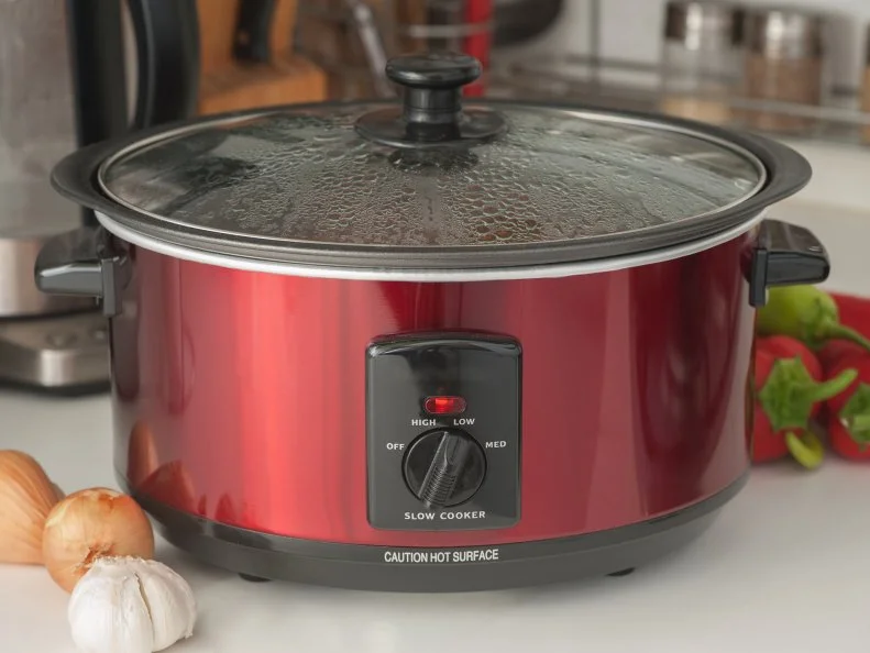 Close up of a slow cooker working on kitchen shelf