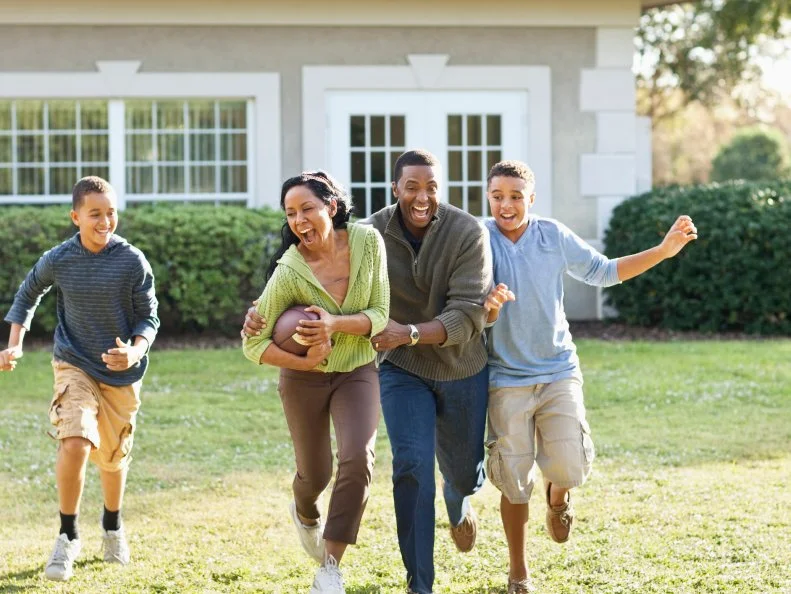 Family playing football in backyard