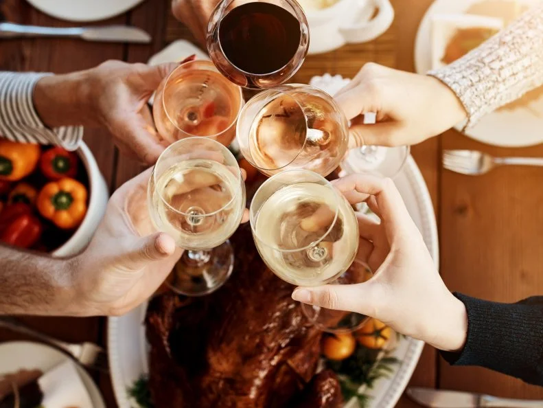 Hight angle shot of an unrecognizable group of people making a toast at a dining table on Thanksgiving