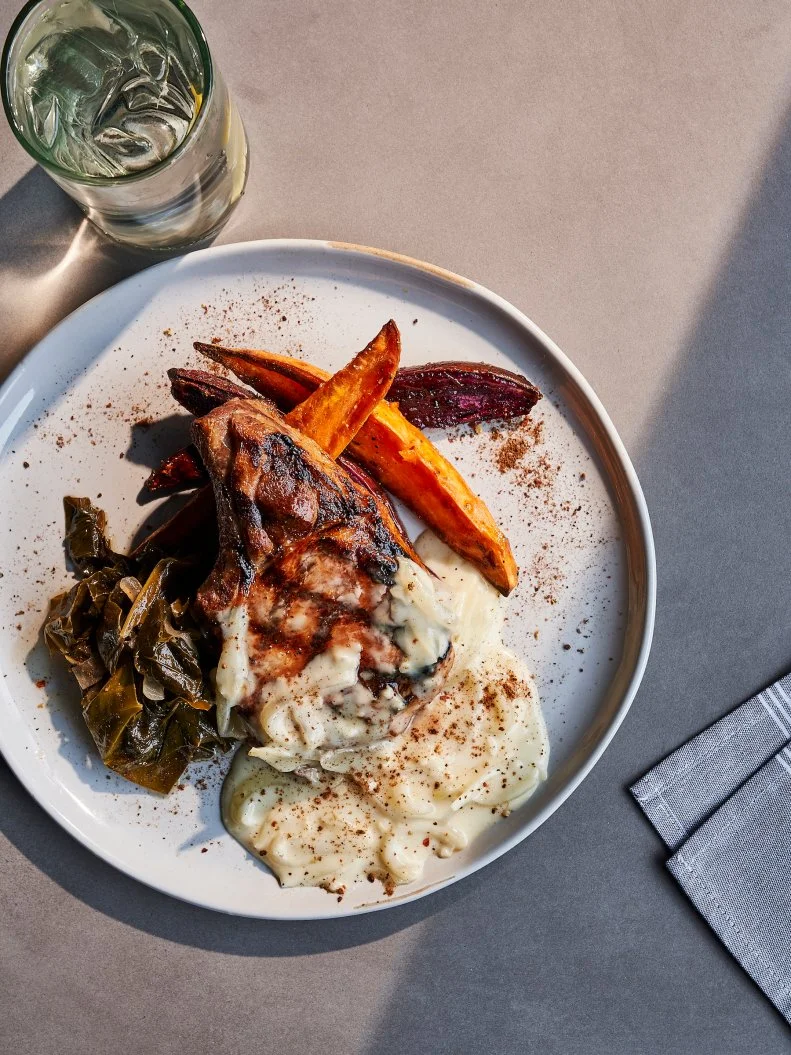 Paying homage to the rich history of African-American culinary traditions in the neighborhood known as The Block, Chef John Fleer and rising star Chef de Cuisine Ashleigh Shanti are putting their spin on Southern Appalachia classics — served family-style — on the ground floor of the restored steel factory that is now The Foundry Hotel.  Think deviled egg spread with Saltines; potlikker-braised chicken wings; fried catfish and waffles; triggerfish and spoonbread; and their wildly popular grilled and smothered pork chop with black pepper hominy gravy, served with sweet potatoes and collard greens.