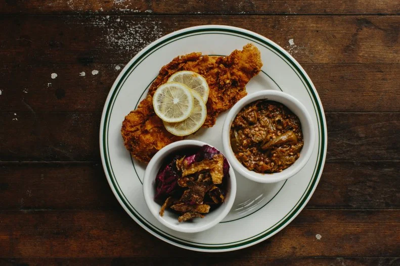 Pitmaster and two-time James Beard Award nominee Elliott Moss has brought Eastern Carolina-style barbecue to Asheville’s South Slope, to much acclaim. Preserving the art of whole hog ‘cue, the menu leads with traditional pulled pork platters and sandwiches. But Moss’ other barbecue specialties are truly raising the barbecue bar. Whether the buttermilk fried chicken sandwich, the bbq hash or Moss’ favorite, the fried catfish sandwich (which is quick cured, smoked on racks on top of the pig and then dredged in seasoned cornmeal before its fried in smoked lard), Buxton Hall has given new meaning to a Southern barbecue joint. 