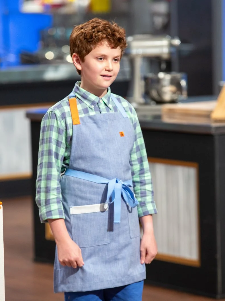 Avner standing in front of judges table, as seen on Kids Baking Championship, Season 8.