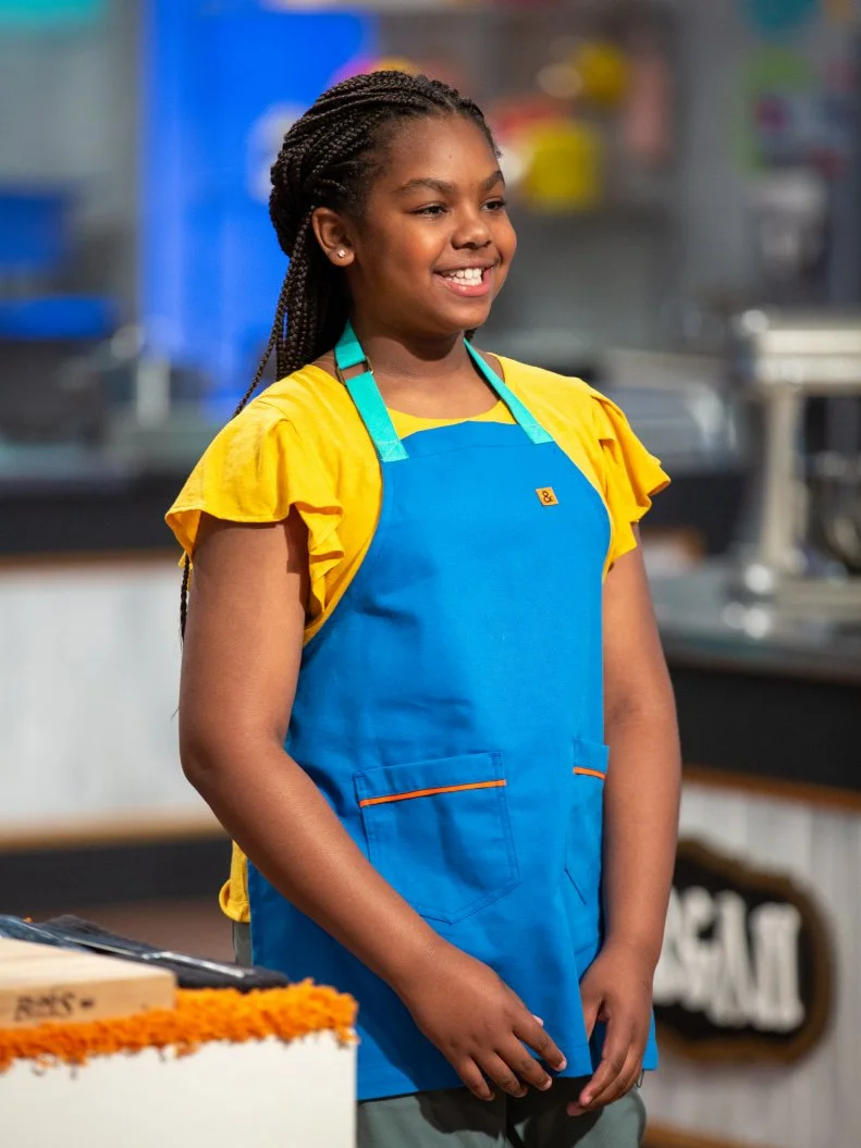 Morgan standing in front of judges table, as seen on Kids Baking Championship, Season 8.