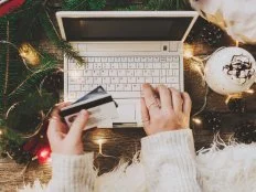 Woman using credit card to shop online, close up