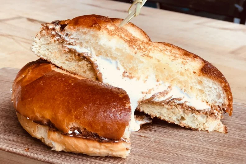 Marshmallow creme, the spreadable mix of marshmallow and corn syrup, wasn’t new when entrepreneur Archibald Query started selling “Marshmallow Fluff” to Somerville, Massachusetts, candy makers in 1917. But none of its predecessors had the same staying power as Query’s creation. By the 1960s, “Fluffernutter” sandwiches were being packed in lunchboxes across the United States. The combo of peanut butter and fluff on white bread is so popular there’s a National Fluffernutter Day (October 8) and the town of its birth still celebrates an annual Fluff Fest every fall. But those who can’t make it to the party can get an upscale version at American Fresh Brewhouse throughout the year. The combination of almond butter and fluff on toasted brioche makes for a decadent treat.